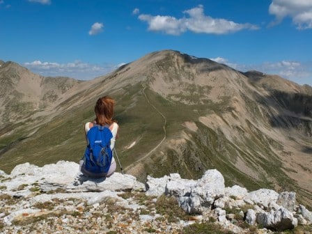 A girl sitting with blue backpack